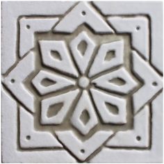 a white tile with an intricate design on it