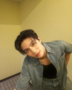 a woman with short black hair is taking a selfie in a bathroom mirror and looking at the camera