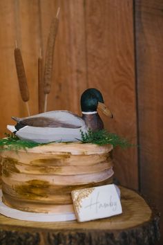 a duck sitting on top of a wooden cake