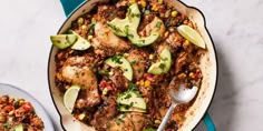 a skillet filled with chicken, rice and avocado