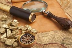 a magnifying glass sitting on top of a map next to some rocks