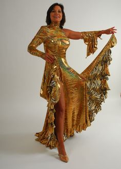 Tango Dress-Spanish Princess will fit size 3/4-9/10...5'6″ or taller, stretchy Be the envy of the dance floor with this stunning Gold Hologram Tango-Paso Doble Dress! Crafted of golden iridescent hologram tiger print lycra, this elegant ensemble boasts lots of flounces, a long sleeve with a peak at the wrist, and shimmering accents courtesy of volcano colored Swarovski rhinestones, which shine several different shades including purple & yellow. Make a statement with two thigh-high slits in the front, and show off your amazing tango leg lines! Sparkle in class and be ready to take on the dance floor in this gorgeous golden dress! You'll feel like a Spanish princess dancing tango or paso doble' in this dress!! This Tango dress design can be custom created in other fabrics & colors, more or l Fitted Full Length Gold Dress, Gold Fitted Full-length Dress, Fitted Full-length Gold Dress, Gold Full-length Fitted Dress, Gold Fitted Dance Dress, Gold Fitted Dress For Dance, Glamorous Fitted Dress For Ballroom, Spanish Princess, Dress Crystal