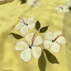 white flowers on yellow fabric with green leaves