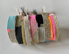 several different colored bracelets are stacked on top of each other