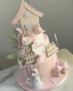 a pink cake decorated with flowers and birds