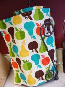 an apple and pear print bag sitting on top of a counter next to a bottle