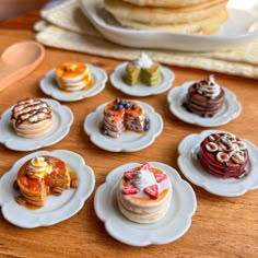 miniature desserts are arranged on small white plates