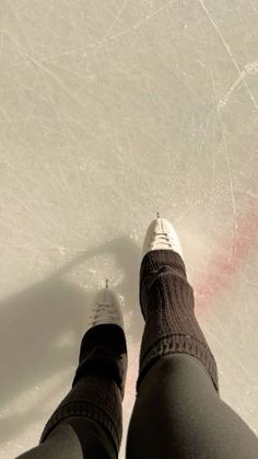 a person standing on an ice rink with their feet in the air