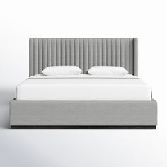 an upholstered bed with white pillows and gray headboard, in front of a plain background