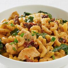 a white bowl filled with pasta and spinach