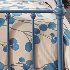 a blue metal bed frame with flowers on it