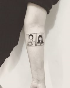 a person with a tattoo on their arm and behind them is an image of two people looking at each other