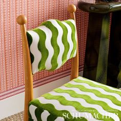 a green and white chair sitting next to a wall