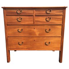 a wooden dresser with four drawers and brass handles