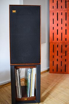 an old record player sitting on top of a wooden shelf in front of a wall