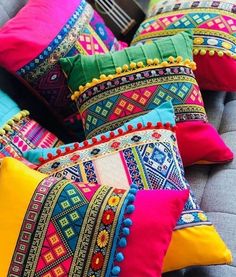 many colorful pillows are on a couch