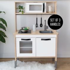 a set of 3 white kitchen cabinets with black labels on the top and bottom shelves