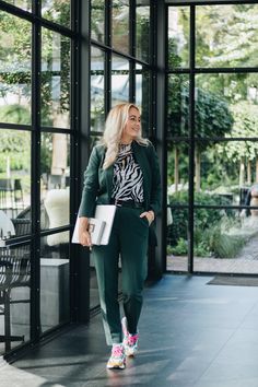 a woman standing in front of a glass building