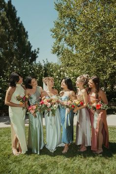 a group of women standing next to each other on top of a lush green field