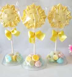 three sun lollipops with yellow bows on them