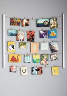 a bunch of pictures hanging on a clothes line with magnets attached to the pegs