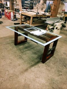 a table that is sitting in the middle of a room with woodworking tools on it