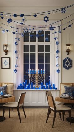 a hanukkah menorah with blue candles in front of a window