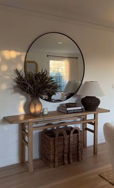 a living room with a table and mirror on the wall