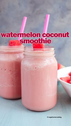 two mason jars filled with watermelon coconut smoothie next to a bowl of strawberries