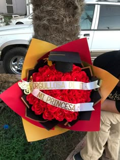 a bouquet of red roses in the shape of a heart is held by a man