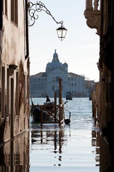 a boat that is sitting in the water by some buildings and a lamp on a pole