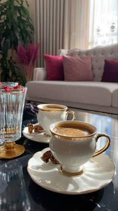 two cups and saucers sitting on a table