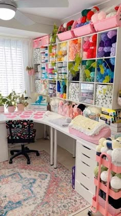 a room filled with lots of crafting supplies on top of a desk next to a window