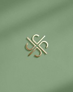 the letter s is inscribed in gold on a green background