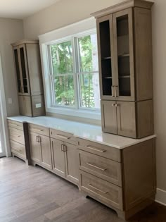 an empty kitchen with cabinets and cupboards in front of a large window on the wall