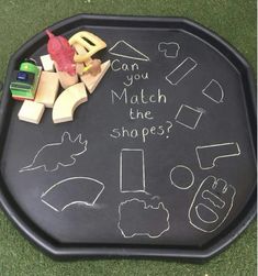 a black tray with chalk writing on it that says can you match the shapes?