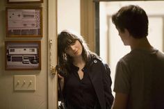 a woman standing next to a man in front of a door