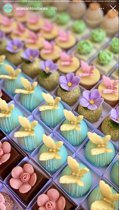 there are many cupcakes with flowers on them in the box and one is blue