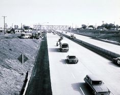 an old black and white photo of traffic on the highway