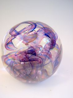 a purple and blue glass ball sitting on top of a table