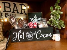 a wooden sign that says hot cocoa with candy and candies in front of it