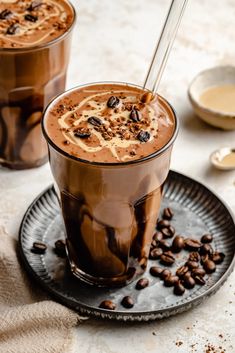 two glasses filled with hot chocolate and coffee beans