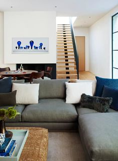 a living room filled with furniture and a fire place in front of a stair case