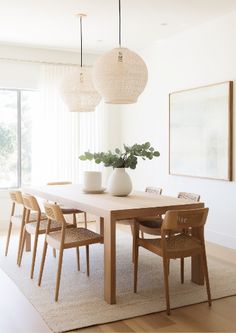 a dining room table with chairs and a vase on it