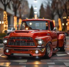 an orange truck parked on top of a checkerboard floor in front of trees