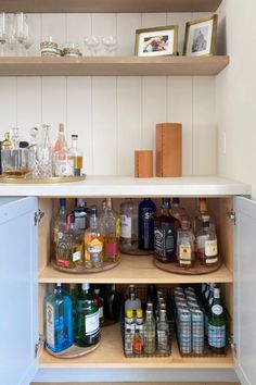 an open cabinet filled with liquor bottles and glasses