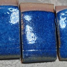 three square blue tiles with white designs on them