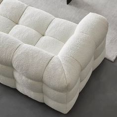 a white couch sitting on top of a gray floor