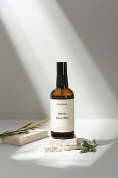 a bottle of soap sitting on top of a white counter next to a plant and block