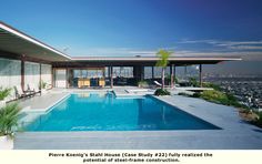 an outdoor swimming pool in front of a modern house with large windows overlooking the city